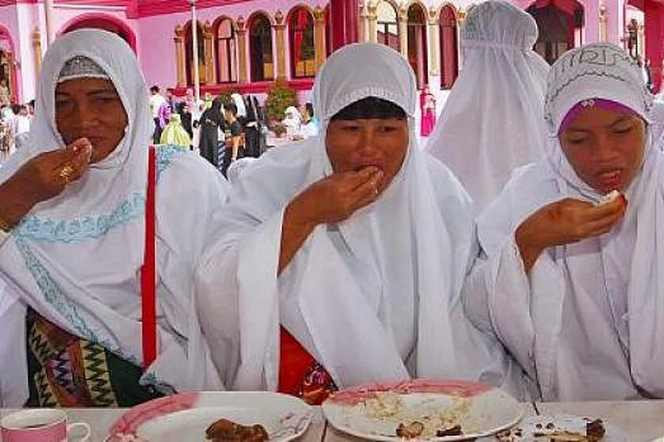 DAH TAK PUASA: Jemaah wanita menikmati juadah Hari Raya selepas menunaikan solat Aidilfitri di perkarangan Masjid Merah Jambu di kota Datu Saudi Ampatuan di Maguindanao, Filipina. - Foto REUTERS