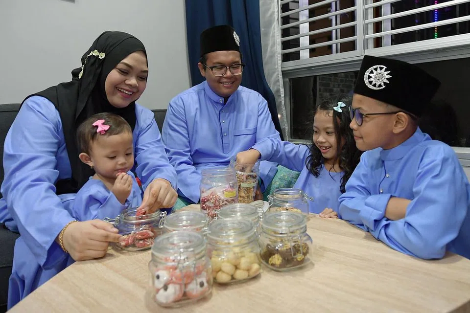 RUMAH IDAMAN: Encik Asmantho Mohamed dan isteri, Cik Nirsya Mohamad Karim seronok menjamu kuih bersama anak-anak (dari kanan) Ashmir Nirzan, Nirlya Ashiqa dan Nirdya Ashira, dalam menyambut Syawal di flat mereka sendiri selepas menetap di flat sewa selama tujuh tahun. - Foto BH oleh NG SOR LUAN