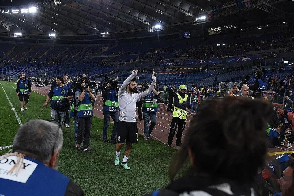 LAMBAIAN KEMENANGAN: Bintang penyerang Liverpool, Mohamed Salah, mengiktiraf sokongan penyokong pasukan selepas kejayaan mengatasi bekas kelab lamanya, Roma, dengan keputusan agregat 7-6. - Foto AFP