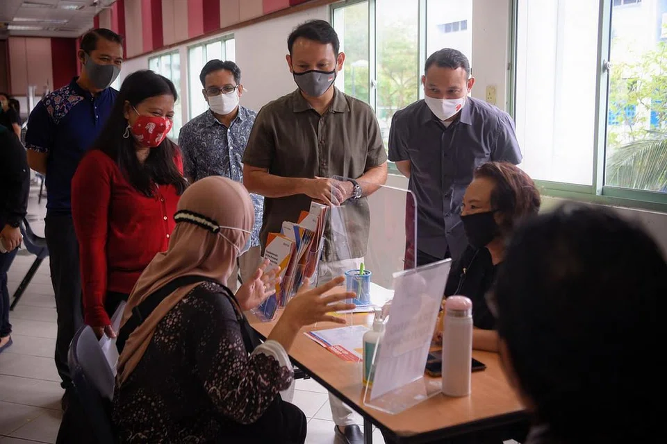 BANTUAN PEKERJAAN: (Berdiri dari kiri) Encik Azriman Mansor dari M³@Marsiling-Yew Tee; anggota Pasukan Bertindak Bidang Tumpuan Empat mengenai Pekerjaan dan Daya Kerja M³ dan AP GRC Sembawang, Cik Mariam Jaafar; Pengarah Eksekutif Mendaki Sense, Encik Faiz Selamat; Encik Zaqy Mohamad; dan Mayor CDC South East dan anggota Pasukan Bertindak Bidang Tumpuan Empat mengenai Pekerjaan dan Daya Kerja M³, Encik Mohd Fahmi Aliman, menemui beberapa individu yang sedang mencari pekerjaan semasa kunjungan mereka ke Pameran Kerjaya 'Jump' di Kelab Masyarakat Marsiling. - Foto fail