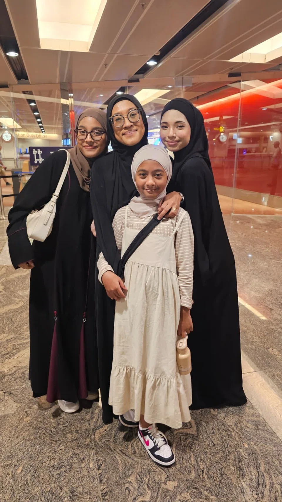 Penulis, Cik Noor Faizah Mustaffa, bersama anak-anaknya di Lapangan Terbang Changi.