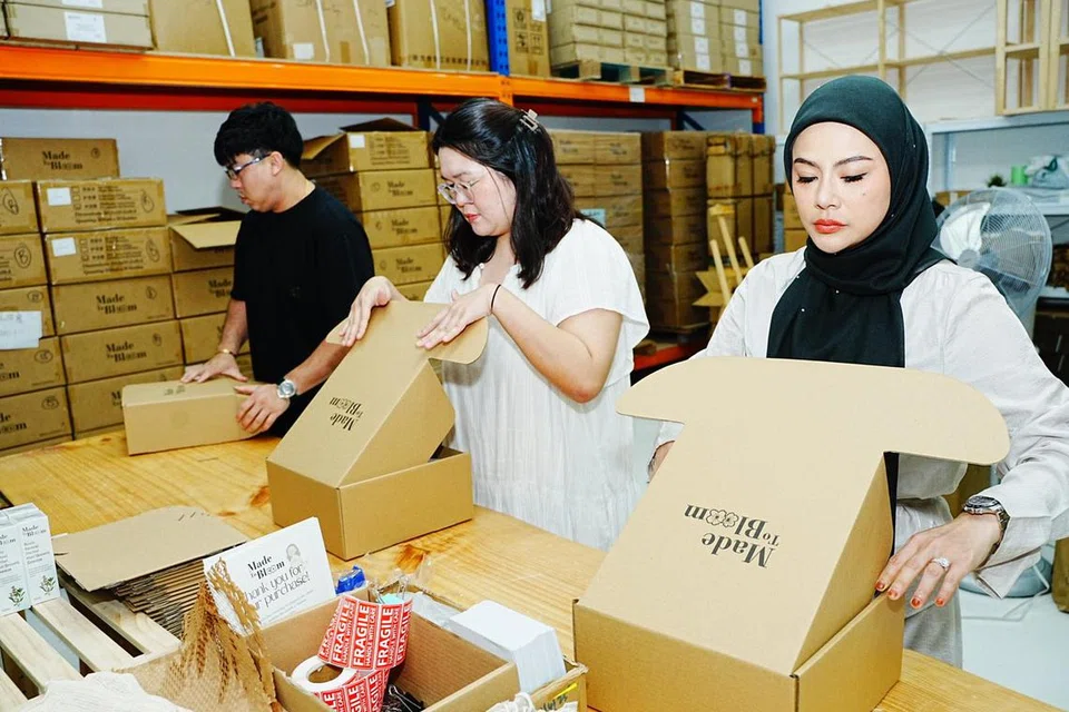 Dalam seminggu, sehingga 500 botol dijual menerusi wadah dalam talian. Cik Belle (dari kanan), Cik Yeo dan Encik Wee kelihatan gigih membungkus produk pesanan dalam talian di pejabat Native Pte Ltd, di 18 Boon Lay Way.