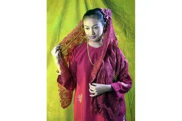 ANGGUN: Wanita Melayu mengenakan baju kurung kain songket motif bunga tabur.- Foto fail