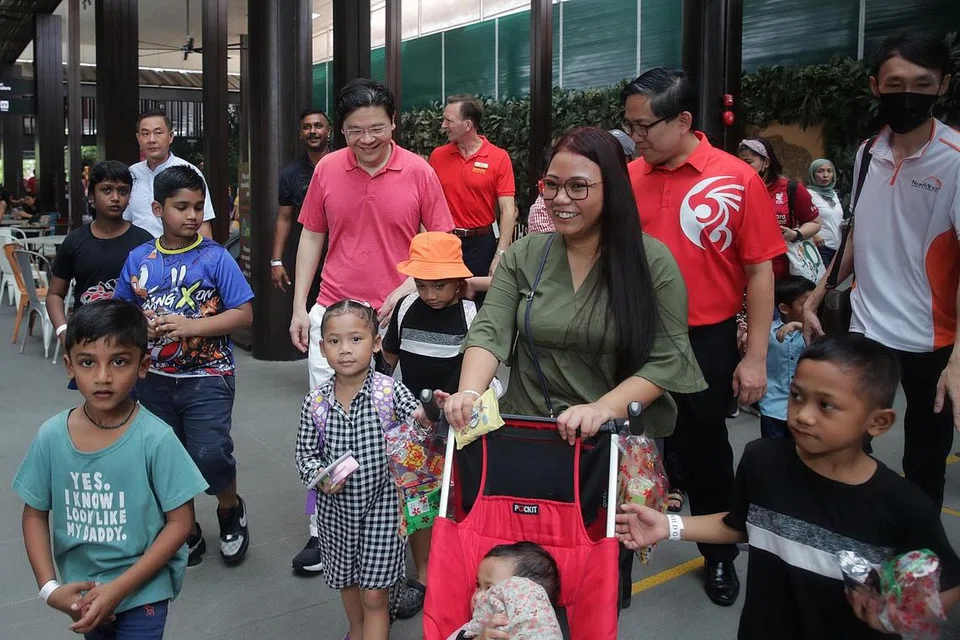 SOKONGAN TAMBAHAN: Encik Lawrence Wong (berkemeja polo merah jambu) menyertai benefisiari program KidSTART dalam satu acara. Keluarga berpendapatan rendah akan mendapat sokongan tambahan bagi membantu mereka mencapai kestabilan dalam kehidupan, menjadikan mereka lebih berdikari selain mempertingkat mobiliti sosial mereka. - Foto fail