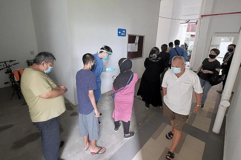 LANGKAH KESAN JANGKITAN: Penduduk Blok 91 Henderson Road beratur bagi ujian swab Covid-19 di sebuah ruang umum berdekatan semalam. - Foto BH oleh GAVIN FOO