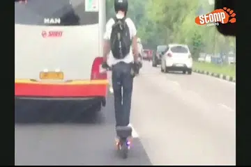 TINDAKAN MENGGADAI NYAWA: Seorang penunggang skuter elektronik dirakam merentasi lorong kiri untuk masuk ke lorong tengah lalu memotong sebuah bas SMRT. Tindakannya yang berbahaya ini dirakam dari sebuah kereta di kawasan Mandai Road. - Foto STOMP