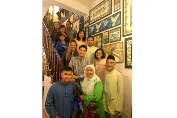 AKTIF SEBAGAI ANGGOTA KELAB JAGA CUCU: Encik Imran (paling kanan, di depan) dan isterinya, Cik Jamaliah (di sebelahnya, berbaju kurung hijau), bergambar bersama anak-anak dan cucunya di rumah mereka di Bedok. - Foto ihsan IMRAM MOHAMED