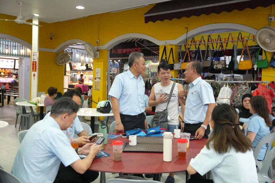 Naib pengerusi Parti Pekerja (WP), Encik Faisal Manap (berdiri, kanan), dan  Encik Jimmy Tan (berdiri, kiri) mendekati penduduk bersama pasukan WP di Blok 476, Tampines Street 43, pada 25 April. 