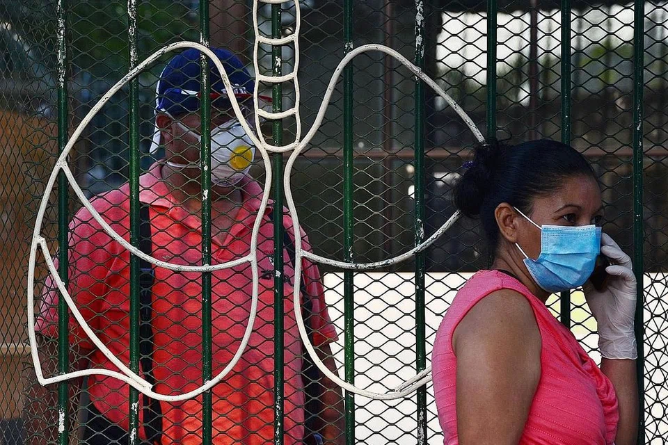 HONDURAS: Seorang wanita yang beratur di luar Hospital Thorax di Tegucigalpa, Honduras, memakai pelitup muka sebagai langkah berjaga-jaga daripada dijangkiti Covid-19. - Foto AFP 