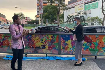 DIRASMIKAN: Menteri di Pejabat Perdana Menteri, Dr Maliki Osman dan Timbalan Ketua Pegawai Eksekutif (CEO) & Ketua Perancang URA, Cik Hwang Yu-Ning merasmikan pemasangan seni lukisan batik yang dipamerkan di sepanjang Geylang Road berhadapan bangunan Wisma Geylang Serai semalam. - Foto BH oleh NUR SYUHRAH HASSAN