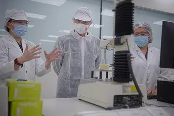 TINJAU KEMUDAHAN: Encik Chan Chun Sing (tengah) mendengarkan taklimat daripada (kiri) Cik Xue Si-Ying, ketua inovasi ASEAN, DuPont Nutrition & Biosciences, manakala pelajar Institut Teknologi Singapura (SIT), Cik Ong Si Pei, menggunakan alat menganalisis tekstur bagi menguji kelembutan roti buatan Jepun. - Foto BH oleh MARK CHEONG