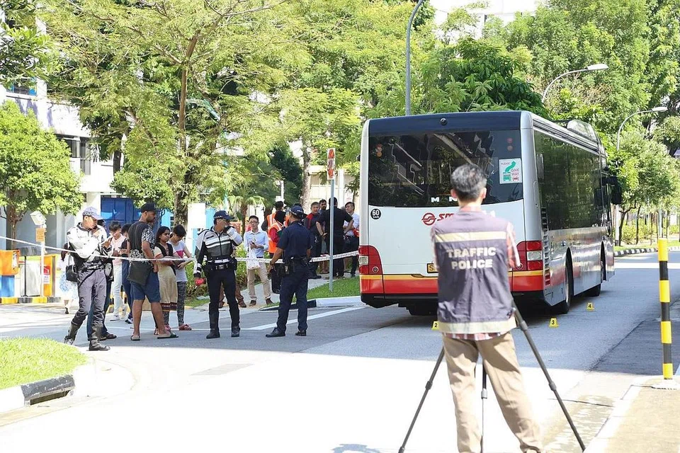 TERPERANGKAP DI BAWAH BAS: Seorang budak lelaki maut selepas tersepit di bawah bas ini sewaktu menyeberang jalan di Choa Chu Kang semalam. - Foto WANBAO