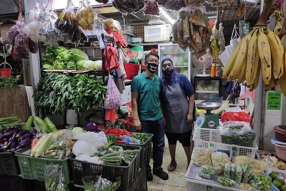 TERPAKSA NAIKKAN HARGA: Cik Rashidah dan suami, Encik Rusidi, yang menjual sayur di Pasar Geylang Serai terpaksa menaikkan harga jualan mereka kerana kini mendapatkan bekalan sayur dari Thailand dan Vietnam yang lebih mahal. - Foto BH oleh LUQMANUL HAKIM