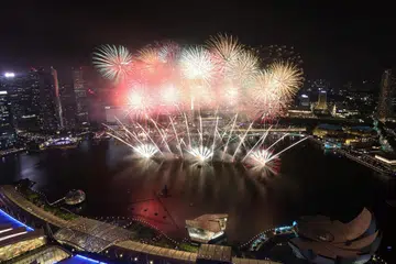 SEMANGAT TAHUN BARU: Walaupun cuaca hujan, orang ramai tetap berkumpul untuk menyaksikan pertunjukan bunga api menyambut ketibaan tahun baru di Marina Bay.