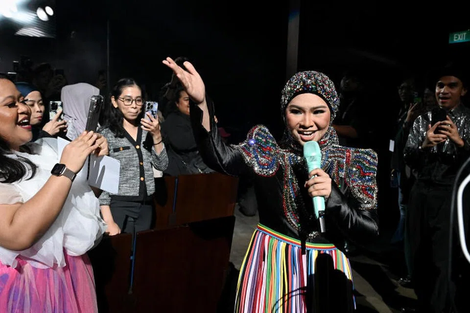 DEKATI PENONTON: Aina Abdul pastikan persembahannya tidak terbatas di pentas sahaja dengan beliau bebas berjalan di kawasan tempat duduk untuk mendekati penonton yang teruja berfoto dengannya.