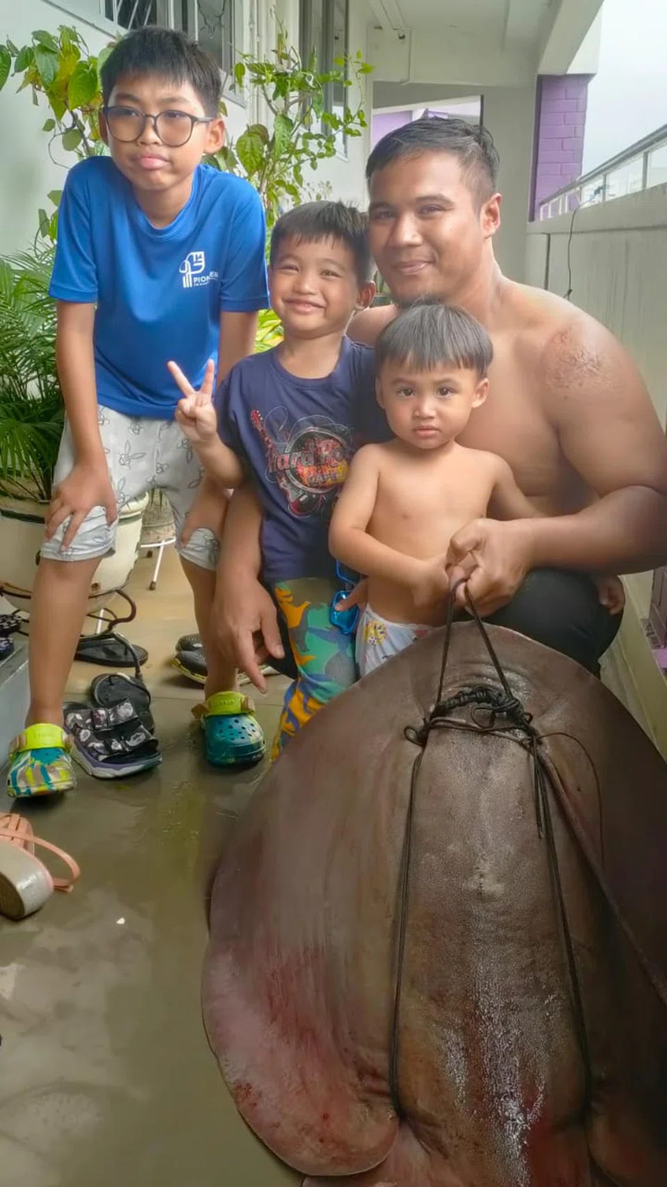 NIKMATI IKAN SEGAR: Encik Muhammad Sufiyan Jumali bersama tiga anaknya bergambar bersama ikan pari yang ditangkap beliau.