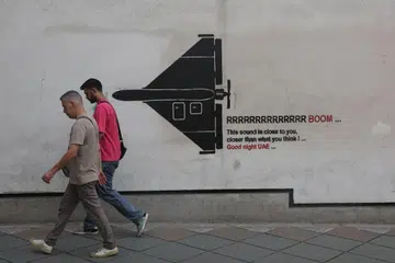 Orang ramai berjalan melewati mural yang menggambarkan sebuah dron Iran di sebatang jalan di Teheran, Iran, pada 9 September. Pertemuan antara Iran dengan beberapa negara Arab Teluk bagi membincangkan laluan sementara untuk kapal melalui Selat Hormuz ditangguhkan tanpa tarikh baru, ketika usaha diplomatik untuk meredakan konflik yang semakin meluas di Timur Tengah berdepan kesukaran.