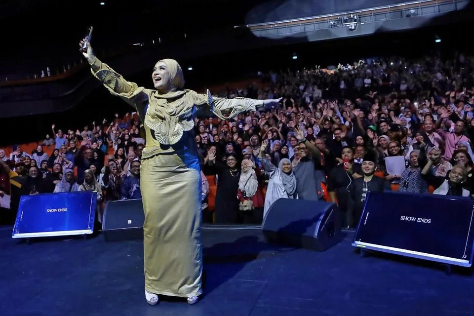 Penyanyi Malaysia, Liza Hanim, berswafoto bersama penonton yang hadir semasa konsert solo pertamanya di Singapura, ‘Liza Hanim 28 Years Journey in Concert’, di The Star Theatre pada 26 April. 