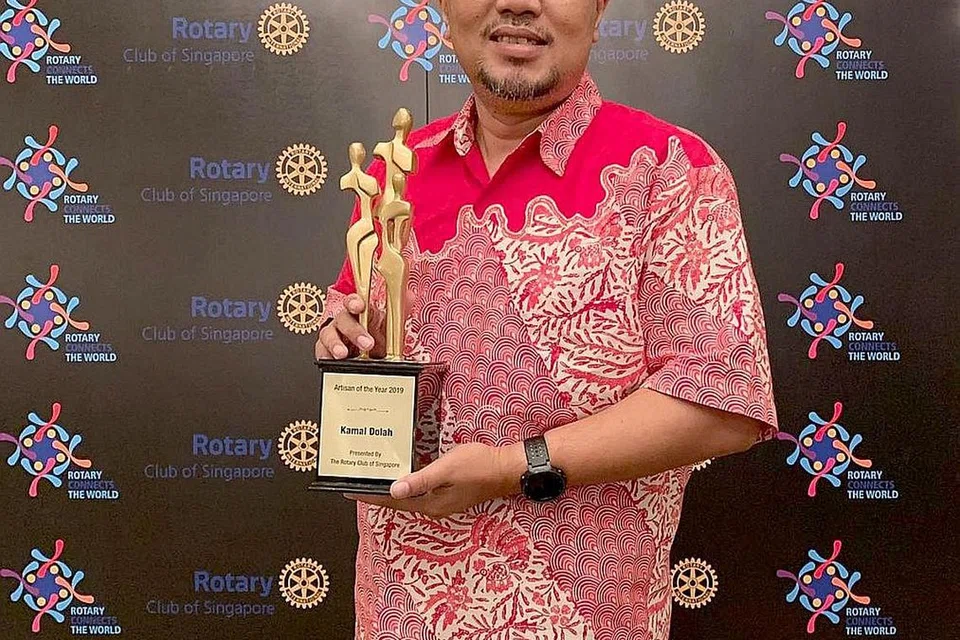 PENGHARGAAN TINGGI: Encik Kamal Dollah dengan trofi Seniman Tahun Ini (2019) yang diberikan oleh Kelab Rotary Singapura di Hotel Shangri-La pada 29 Jun. - Foto ihsan KAMAL DOLLAH