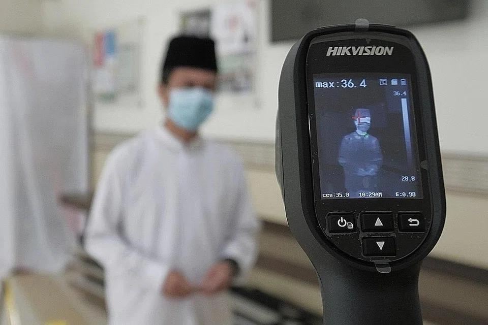 LANGKAH BERWASPADA: Jemaah yang ingin memasuki masjid selepas ia dibuka semula perlu melalui beberapa pemeriksaan dan langkah pencegahan, termasuk pemeriksaan suhu badan. Mereka juga perlu mengimbas kad pengenalan bagi sistem Safe Entry.