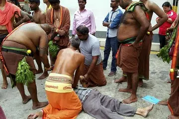 PANTAS MEMBANTU: Beberapa penganut Hindu yang memakai pakaian adat mereka membantu dan memberikan bantuan pernafasan cemas (CPR) kepada seorang lelaki tua yang tidak sedarkan diri. - Foto FACEBOOK KUMAR V