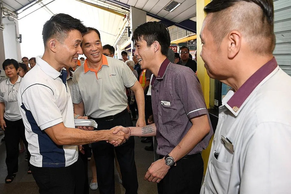 UCAP TERIMA KASIH: Dengan pelancaran kempen baru ini, Encik Baey (depan, kiri) berharap orang ramai boleh merakam penghargaan terhadap jasa pekerja pengangkutan awam. Beliau menemui pekerja tersebut di stesen MRT dan pusat pertukaran bas Tampines semalam. - Foto BH oleh KHALID BABA