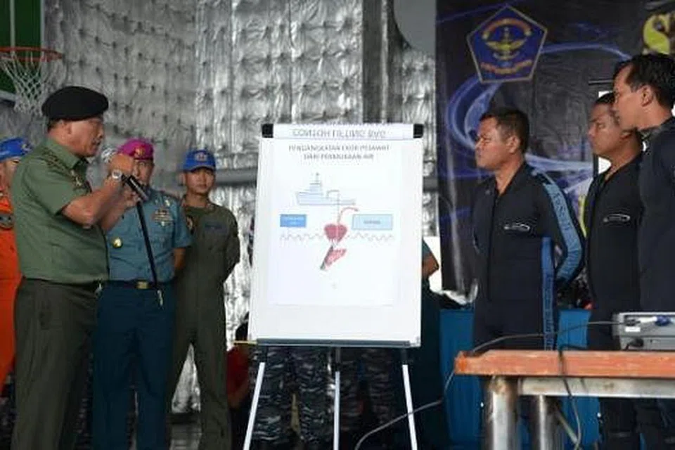 BERI PENJELASAN: Pasukan penyelam Indonesia di kapal KRI Banda Aceh diberi penjelasan mengenai operasi selanjutnya semalam untuk mencari kotak hitam pesawat AirAsia QZ8501. - Foto AFP