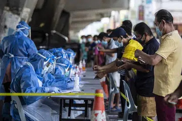 Pekerja jagaan kesihatan bertugas mendaftar pekerja asing bagi ujian Covid-19.