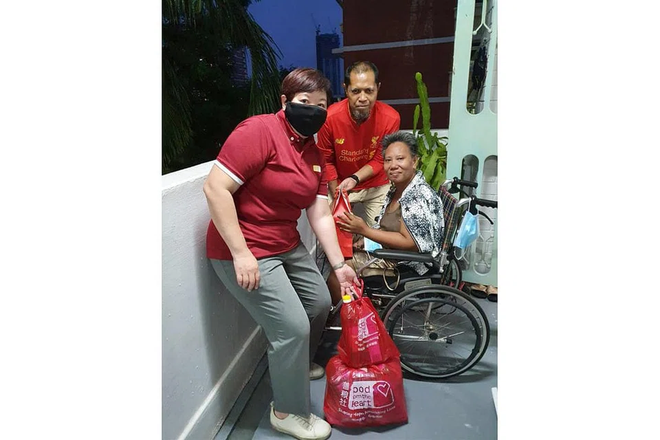 SEBAR KECERIAAN: Penerima pek makanan menerusi insiatif antara Food from the Heart dengan Coca-Cola Singapore bergambar bersama Cik Sim Bee Hia (kiri), Ketua Pegawai Eksekutif, Food from the Heart. - Foto FOOD FROM THE HEART