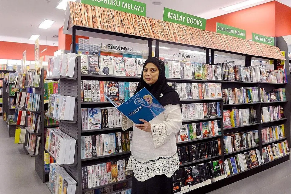 ANEKA JENIS BUKU MELAYU: Buku-buku Melayu yang merangkumi buku masakan, fiksyen, agama dan kanak-kanak kini boleh didapati di tiga lagi cawangan kedai buku Popular di gedung Bedok Mall, Causeway Point dan Jurong Point selain gedung One KM. Gambar menunjukkan Cik Rokiah Rajib, pegawai promosi produk di kedai buku Popular di bahagian buku Melayu di gedung One KM. - Foto TAUFIK A. KADER