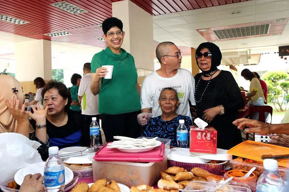 SARAPAN DENGAN PENDUDUK: Dr Fatimah (baju hijau) bersama penduduk menjamu sarapan yang disiapkan penduduk sendiri di Blok 22 Haig Road semalam. - Foto ZAOBAO