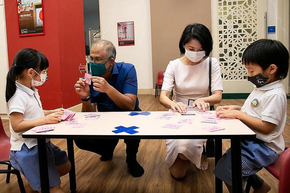 TINJAU TAJAKA: Encik Masagos Zulkifli dan Cik Sun Xueling bermesra bersama beberapa kanak-kanak semasa lawatan mereka ke pusat prasekolah Learning Vision di Pasir Panjang semalam. - Foto MSF