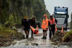 PUTING BELIUNG: Tanah runtuh berlaku disebabkan hujan Puting Beliung Debbie dengan pekerja terpaksa membersihkan laluan jalan raya utama antara Napier dan Taupo di North Island, New Zealand. - Foto REUTERS