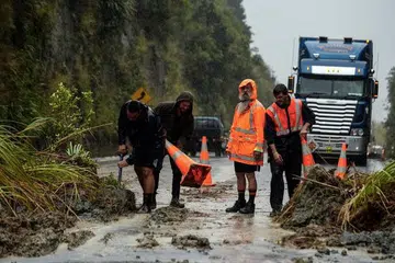 PUTING BELIUNG: Tanah runtuh berlaku disebabkan hujan Puting Beliung Debbie dengan pekerja terpaksa membersihkan laluan jalan raya utama antara Napier dan Taupo di North Island, New Zealand. - Foto REUTERS
