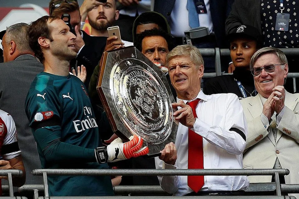 SENYUM SEPANJANG MUSIM?: Bos Arsenal, Arsene Wenger (kanan), meraikan kejayaan pasukannya memenangi Perisai Masyarakat Ahad lalu. Persoalannya ialah dapatkah Arsenal kekal konsisten sepanjang musim? - Foto REUTERS 