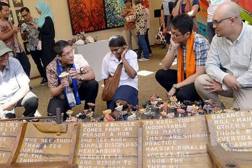 LAMBANGKAN MASYARAKAT: Dr Mohd Maliki meninjau karya 'The Boat of Hope' dengan sampan sebagai melambangkan masyarakat yang akan memimpin, manakala botol-botol pula diisi dengan catatan harapan. Foto-foto TAUFIK A. KADER 