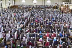 COVID-19 DI INDONESIA: (Gambar atas) Pekerja menggulung rokok diasingkan daripada pekerja lain menggunakan plastik di sebuah kilang rokok di Malang, Jawa Timur, sedang WHO menggesa Indonesia mengutamakan ujian Covid-19 bagi kes yang disyaki dijangkiti koronavirus itu. - Foto AFP