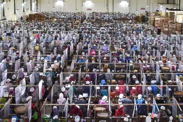 COVID-19 DI INDONESIA: (Gambar atas) Pekerja menggulung rokok diasingkan daripada pekerja lain menggunakan plastik di sebuah kilang rokok di Malang, Jawa Timur, sedang WHO menggesa Indonesia mengutamakan ujian Covid-19 bagi kes yang disyaki dijangkiti koronavirus itu. - Foto AFP