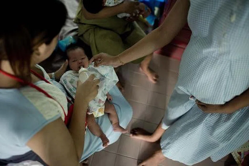 SENASIB: Ying, 16 tahun, yang hamil sedang sarat mengandung, menyentuh bayi yang diberi susu oleh ibunya di rumah perlindungan di Persatuan bagi Promosi Taraf Wanita (APSW) di Bangkok. Dia tinggal di sini kerana ibu bapanya takut dia akan berasa malu jika bertemu rakan-rakannya dalam keadaan Ying hamil. - Foto AFP