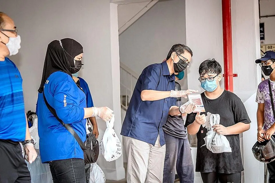 PUPUK KESEDARAN: Menteri Negara (Pembangunan Negara merangkap Ehwal Dalam Negeri) Profesor Madya Muhammad Faishal Ibrahim dilihat membantu pengagihan habuan Ramadan di Yishun Street 71. - Foto BH oleh NUR DIYANA TAHA