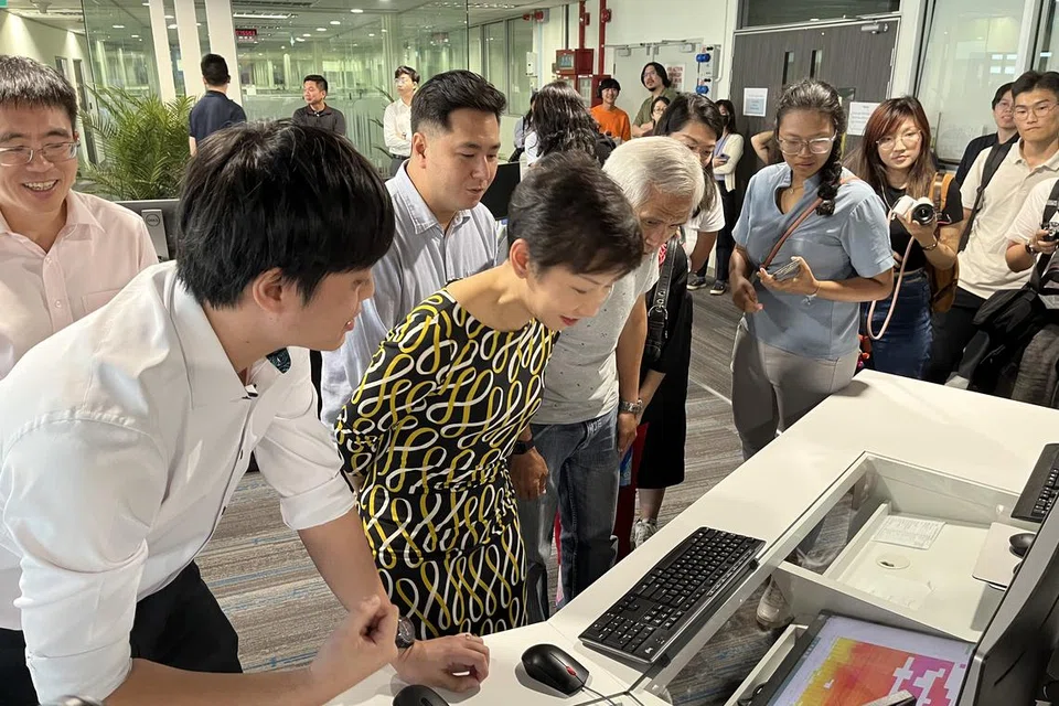 DIBERI TAKLIMAT: Menteri Kemampanan dan Sekitaran, Cik Grace Fu melawat pejabat Khidmat Kaji Cuaca Singapura yang terletak di Lapangan Terbang Changi ketika pelancaran Panduan Tekanan Haba pada Isnin.