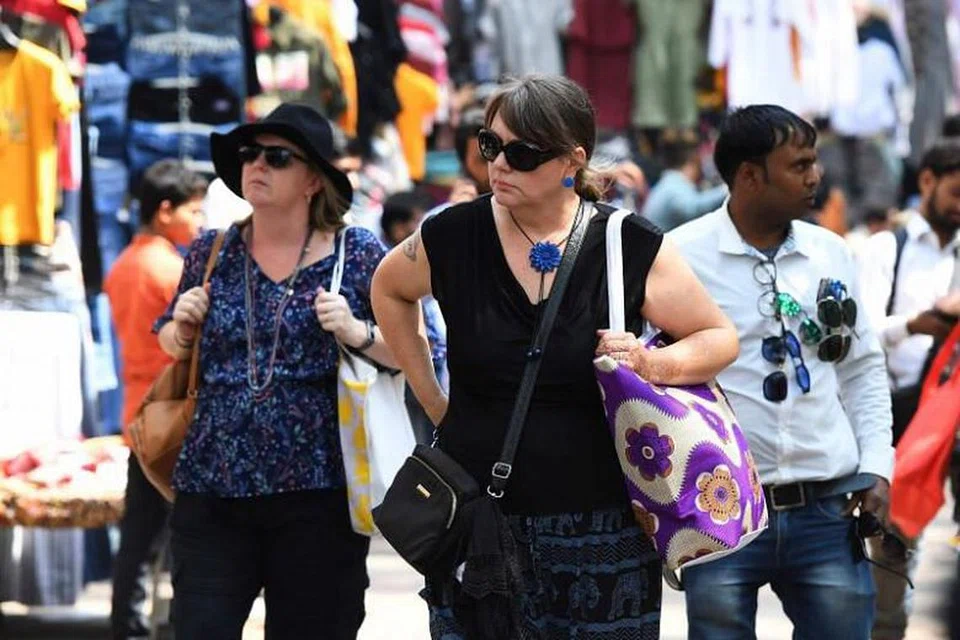 Pelancong asing sedang berjalan-jalan di sekitar New Delhi pada 12 Mac. 