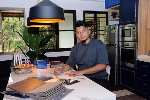 KERJA LEMBUR: Encik Khai terpaksa 'turun padang' membantu menjalankan kerja-kerja ubah-elok kerana kekurangan pekerja. - Foto BM oleh KHALID BABA