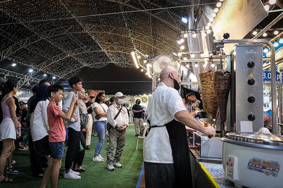 PILIHAN RAMAI: Pelanggan dilihat sibuk membeli kebab, antara makanan kegemaran ramai yang biasanya dibeli di bazar setiap tahun. Sementara itu, seorang pelanggan pula dilihat sedang meninjau capal.