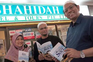 KERJASAMA BUAT JULUNG-JULUNG KALINYA: (Dari kiri) Penyair setempat Cik Faridah Taib dan Encik Mohd Khair Mohd Yasin mengongsi perasaan mereka melakukan ibadah umrah menerusi puisi dalam antologi berjudul Perjalanan Suci yang dibiayai Shahidah Travel & Tours yang dimiliki Encik Ayoob Angullia. . - Foto NURUL AIN RAZALI
