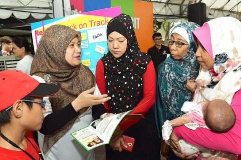 TINGKAT KESEDARAN TENTANG KETAGIHAN: Cik Habibah (dua dari kiri) bercakap dengan beberapa pengunjung di acara Hari Kesedaran Ketagihan Nasional di Marine Parade Promenade semalam. - Foto MOHD KHALID BABA