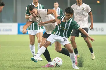 Penyerang Tanjong Pagar, Boris Kopitovic (kiri) cuba dapatkan bola daripada pemain Geylang International, Nazrul Nazari. Walaupun Tanjong Pagar terpaksa beraksi dengan sembilan pemain, mereka mempamerkan semangat juang yang kuat untuk cuba bangkit dan hanya kalah tipis 1-0.