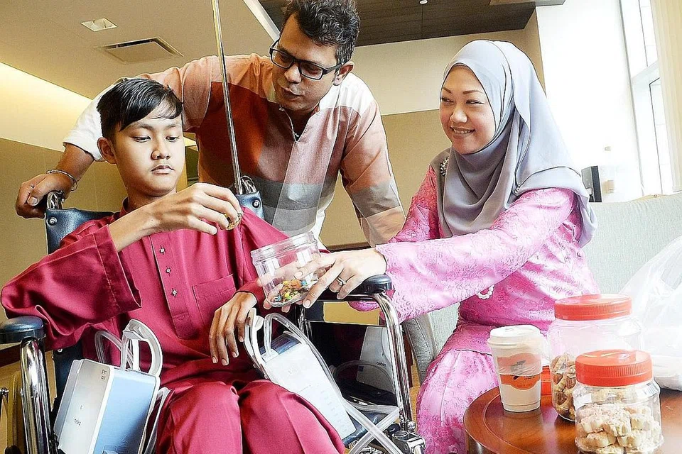 TETAP MAHU BERAYA: Syaqir Ali, yang telah hampir tiga bulan dirawat di Hospital Mount Elizabeth Novena akibat masalah paru-paru akibat sepsis, meminta ibu bapanya, Encik Mohd Ali dan Cik Siti Huzainawati, membelikannya baju Melayu baru untuk menyambut Raya. - Foto JOHARI RAHMAT