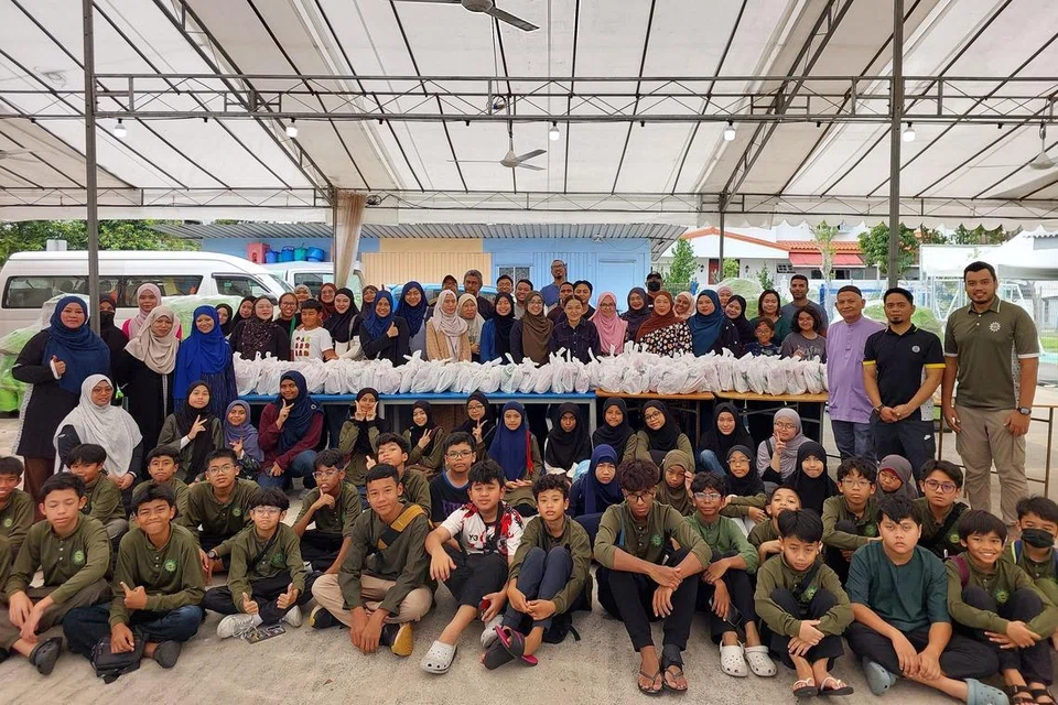 Sama-sama memberi bantuan tenaga, para sukarelawan bergambar bersama kakitangan dan Presiden Persatuan Muhammadiyah, Ustaz Muhammad Azri Azman, selepas mereka selesai membungkus hamper pra-Syawal. 