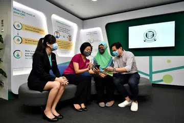 TOKOKAN CPF: (Dari kiri) Cik Lim Hui Kiang, eksekutif kanan khidmat pelanggan Lembaga CPF, Cik Sim Ann, penjaja dan penduduk Bukit Timah, Cik Salmiah dan Dr Kenny Sim Mong Keang, CEO FSK Advisory dan penderma di Pusat Khidmat CPF Maxwell. - Foto BH oleh LIM YAOHUI